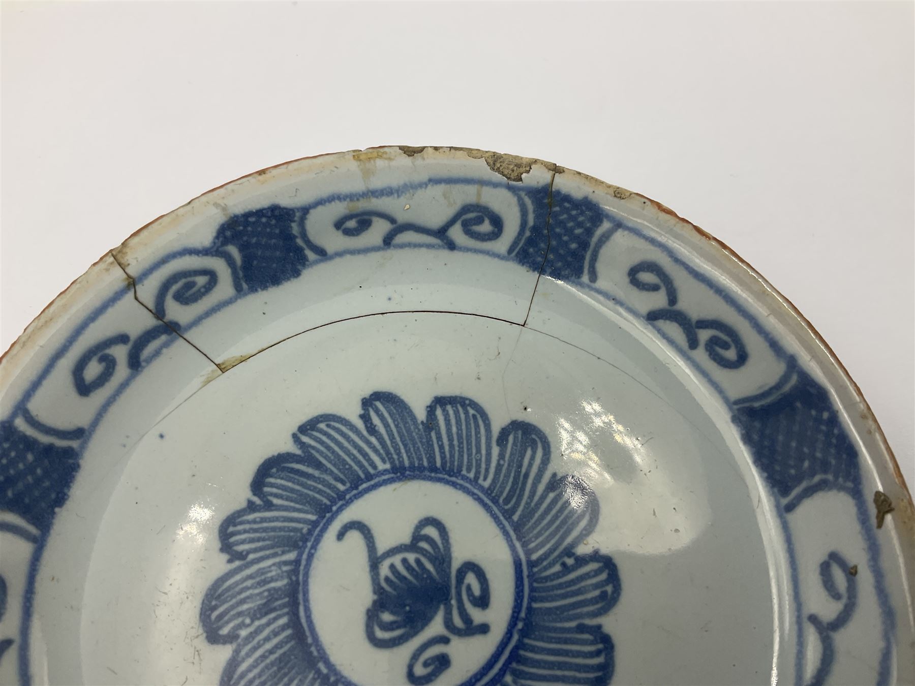 Rare 18th century English delft coffee cup and saucer, circa 1760, probably Liverpool, the cup painted with rockwork, flowers and bird, the saucer painted with central stylised flower head and lattice and scroll border, cup H6cm, saucer D10.5cm
