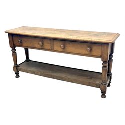 Late 19th century oak potboard dresser base, rectangular top over two frieze drawers with turned wooden handles, raised on four ring turned and tapering supports with block feet, united by a full-width lower potboard