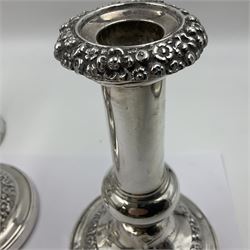 Four George III silver candlesticks, each upon knopped stem and weighted circular stepped foot, the foot and removable sconce repousse decorated with a band of flower heads, hallmarked to sconce and foot Thomas & John Settle, Sheffield 1820, H17.5cm
