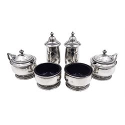 1930s silver six piece cruet set, comprising two peppers, two open salts and two mustard pots with covers, each of plain form with gadrooned rims, mustard pots and peppers each with gadrooned finials, hallmarked Mappin & Webb Ltd, Birmingham 1932 and 1935, mustard pots and salts with blue glass liners