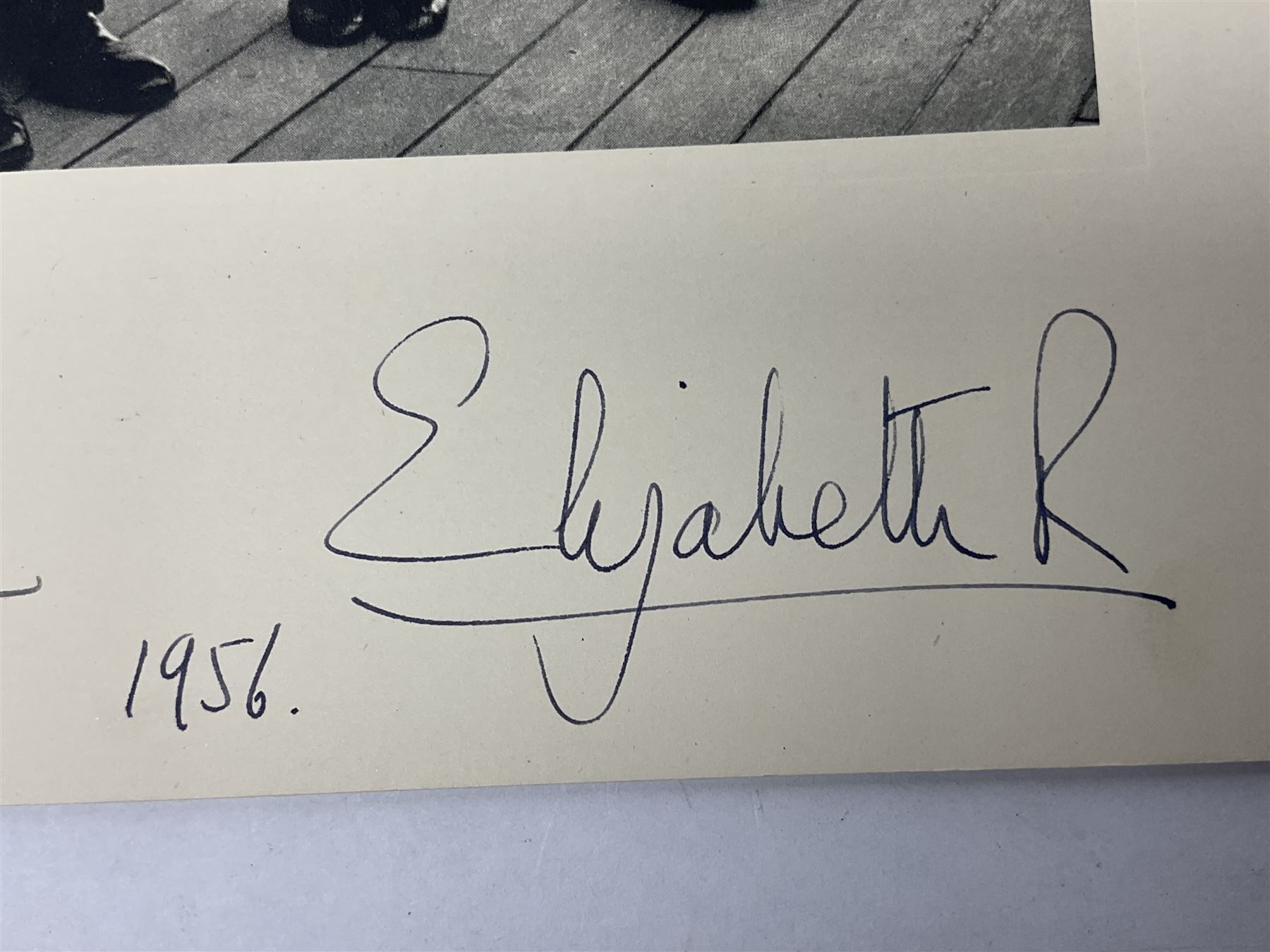 HM Queen Elizabeth II and HRH The Duke of Edinburgh - signed 1956 Christmas card with gilt embossed crown to cover, black and white photograph of the smiling Royal Couple with Prince Charles and Princess Anne on board Britannia, signed in ink 'Philip 1956 Elizabeth R',