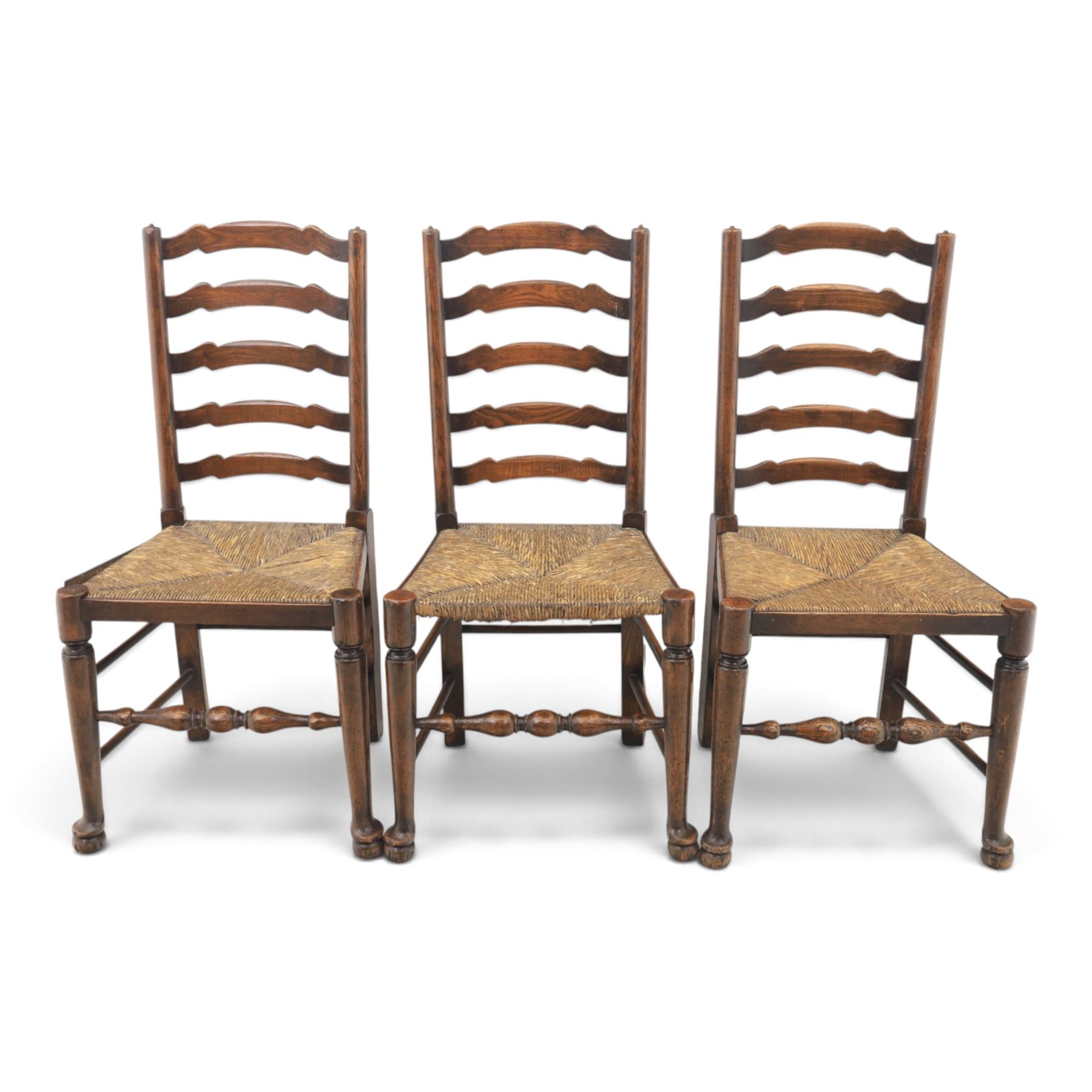 19th century set of six ash and elm ladderback dining chairs, shaped ladder backs above rush seats, raised on turned front supports with pad feet, united by turned stretchers