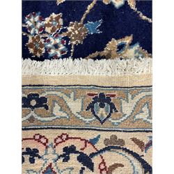 Central Persian Nain carpet, wool and silk inlaid, indigo ground field with central rosette floral medallion, decorated with interlaced branch and stylised plant motifs, repeating trailing floral design border 