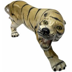 Large Lomonosov model of a tiger, L29cm, with printed mark beneath, together with another ceramic figure of a tiger, unmarked, L37cm. 