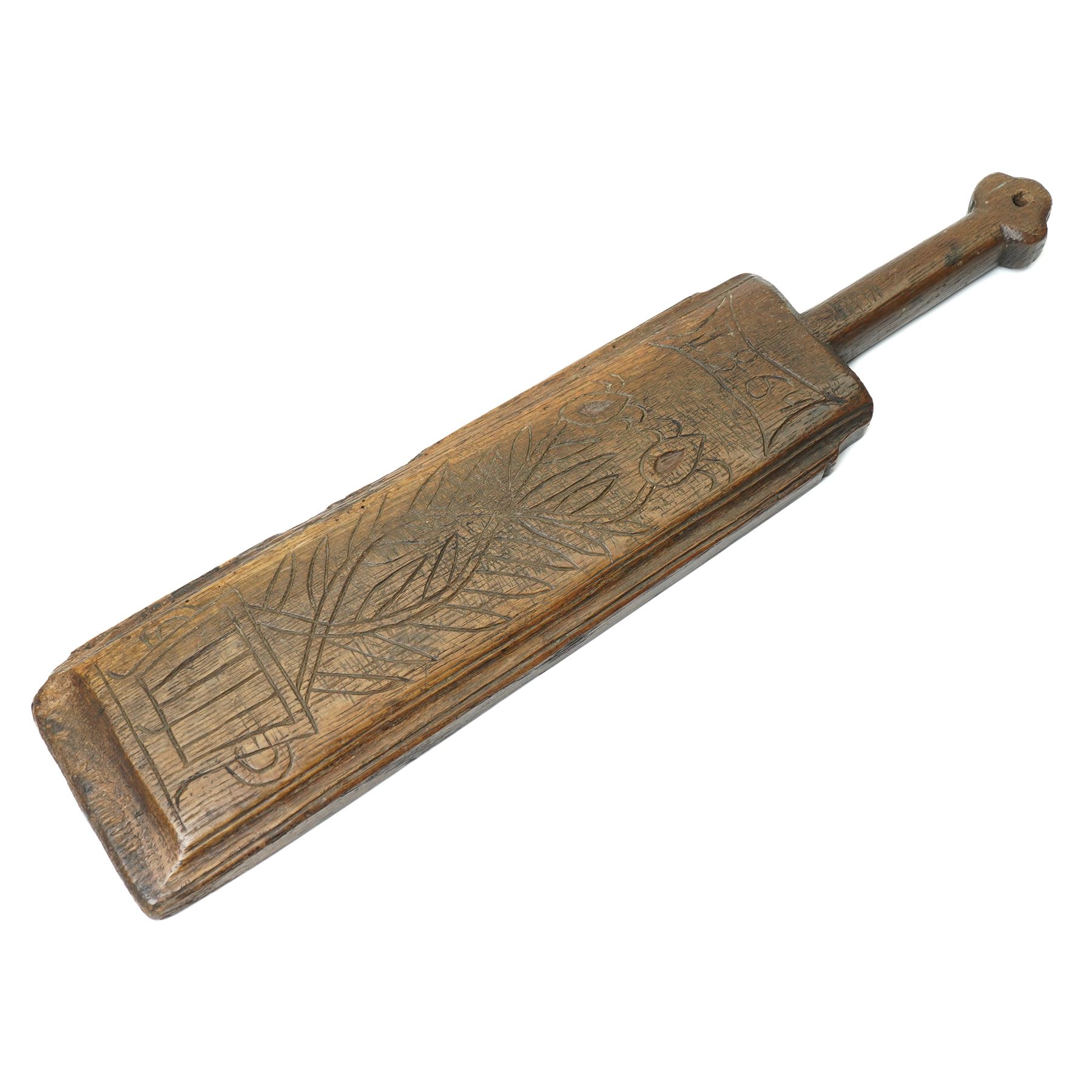 19th century oak mangle board, incised date 1864, decorated with a flower emerging from a pot, W51cm 