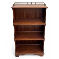 Mid-20th century mahogany open bookshelf, the rectangular top with a brass balustrade gallery, over three shelves each supported by turned column uprights, on shaped apron base