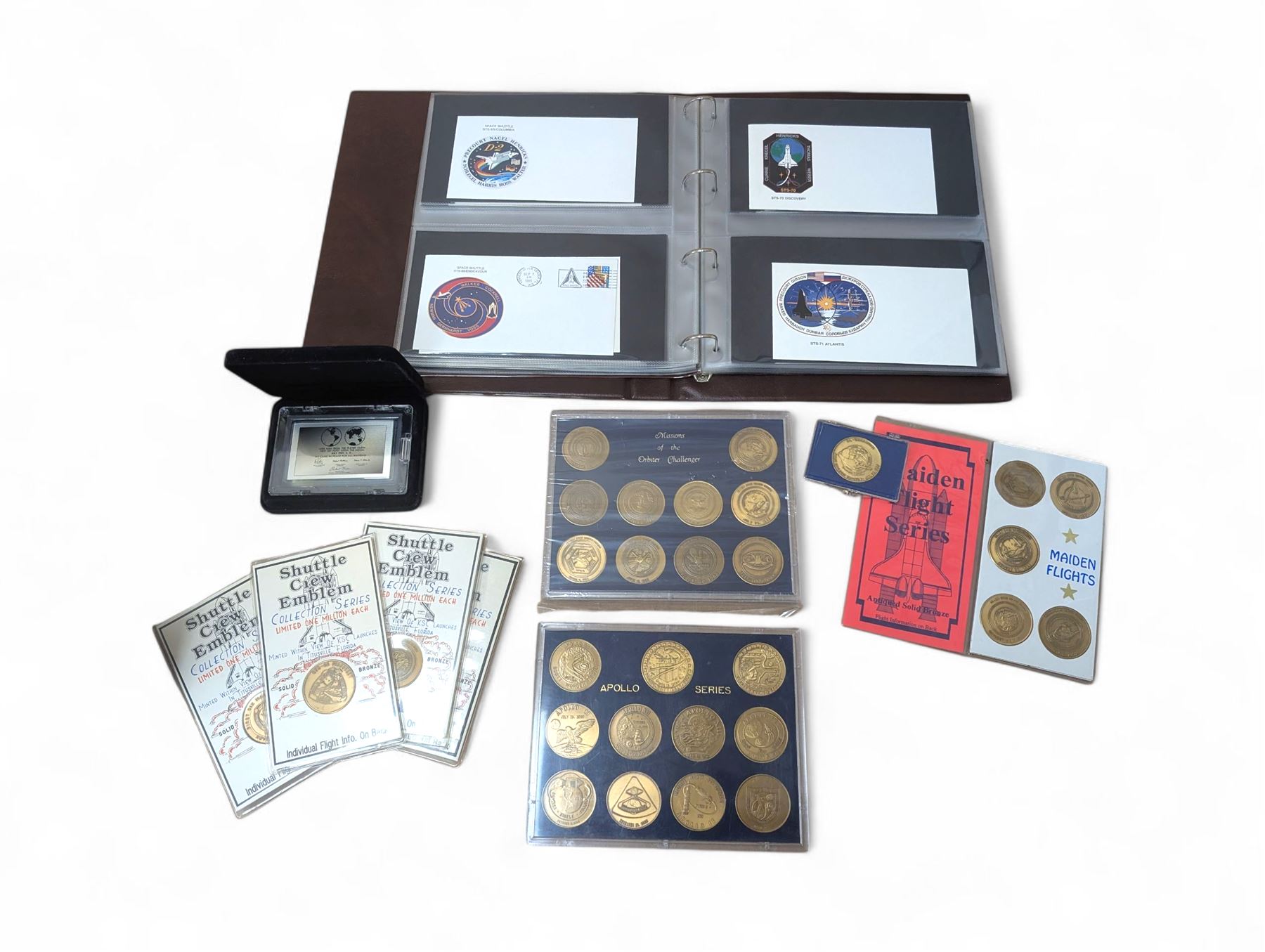 Nasa Space Shuttle program commemorative items, including album of stamp covers, telephone cards, five Shuttle Crew Emblem Collector's Series medallions, Maiden Flights bronze medallions, Missions of the Orbiter Challenger set of medallions and Apollo series medallions
