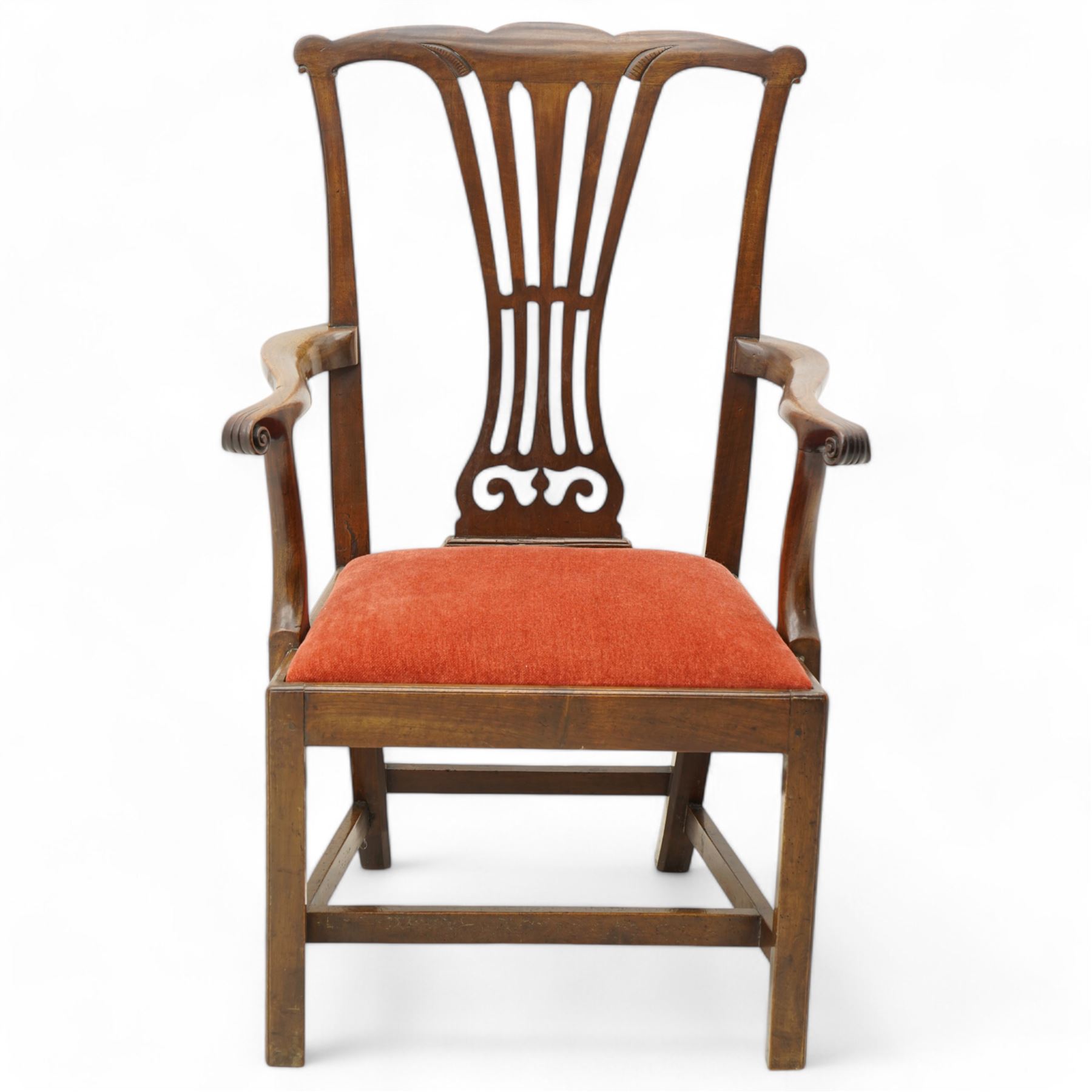 George III mahogany open elbow chair, shaped cresting rail over pierced splat, shaped arms with scroll carved terminals, drop-in seat upholstered in red fabric, on square supports with moulded edge united by plain stretchers 