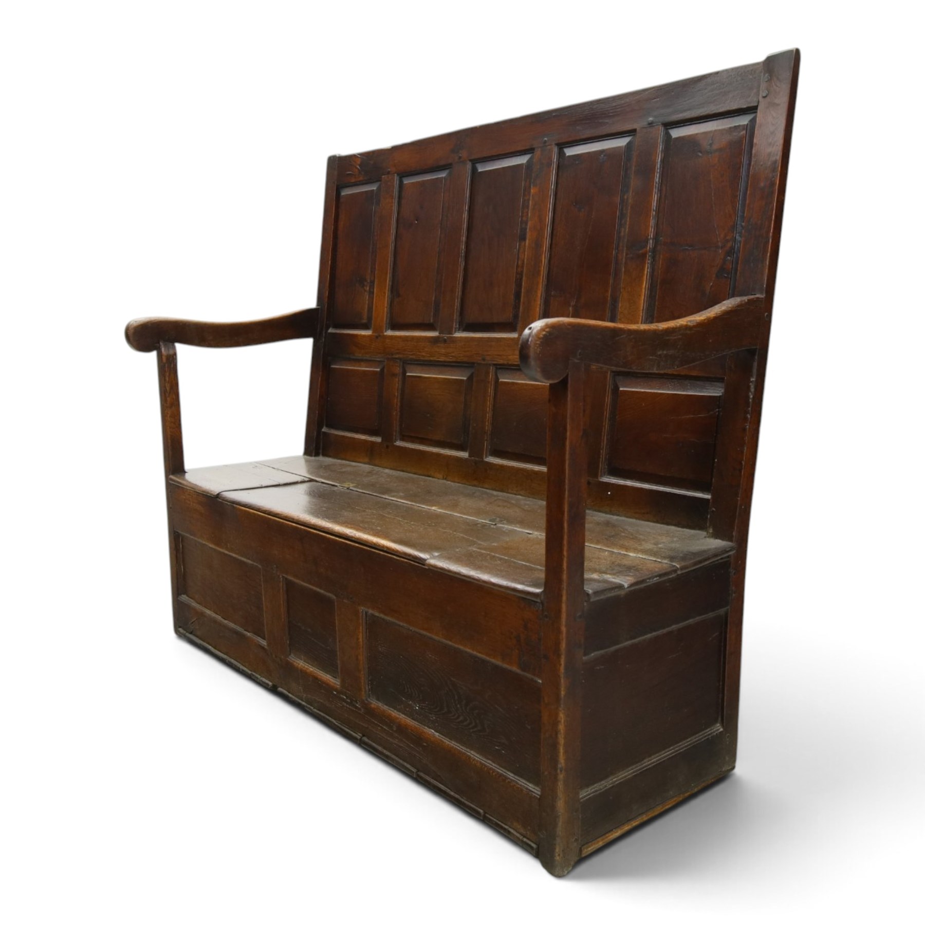 18th century oak high-back settle or hall bench, the panelled back and arm terminals over a hinged box seat, panelled front on short stile feet