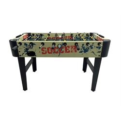 Sportcraft table football game raised on supports with stretcher
