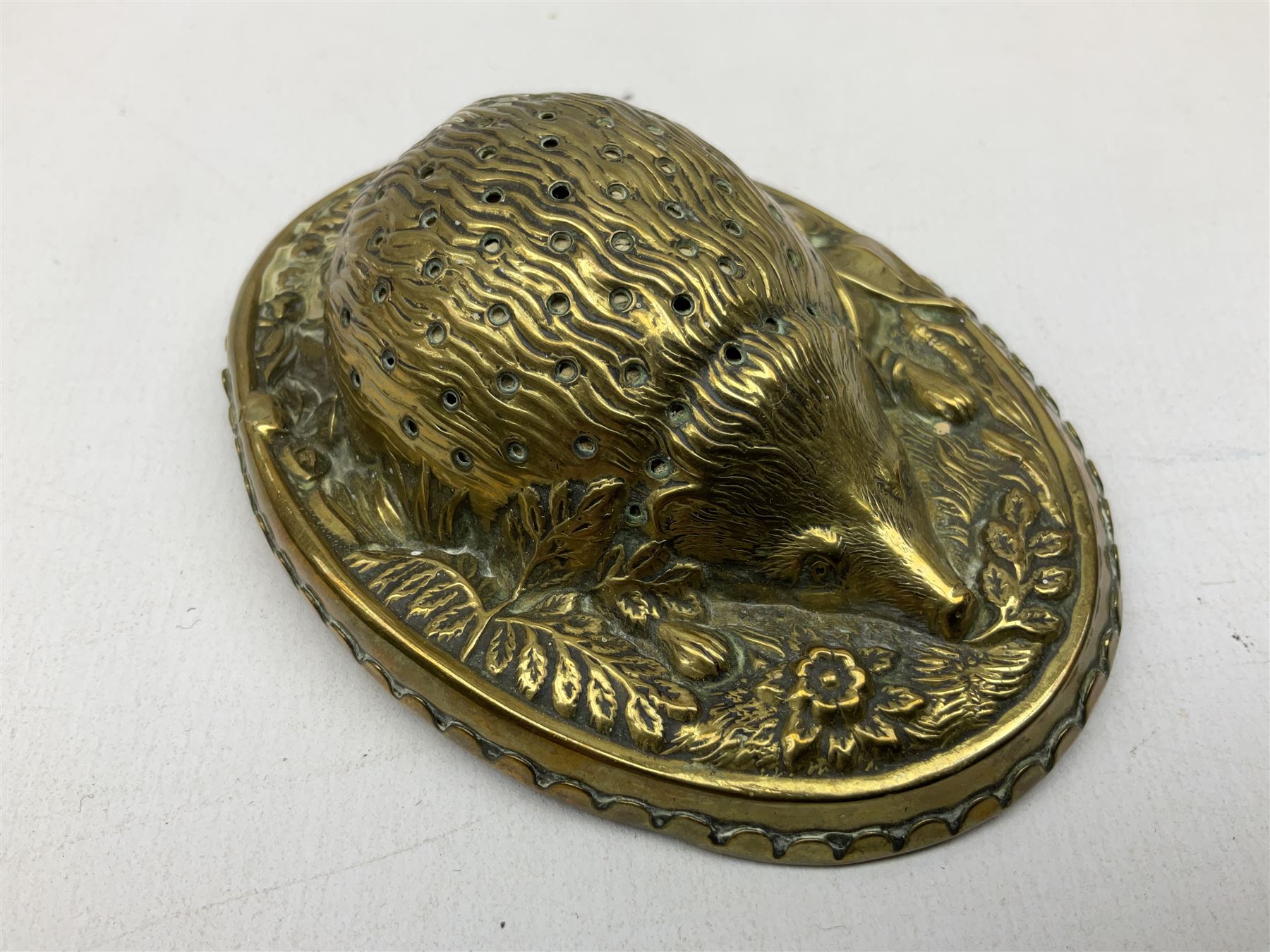 W Avery & Son brass oval pincushion in the form of a hedgehog, and horseshoe needle packet box both inscribed to base 'W. Avery and Son, Redditch', with registration mark, pin cushion L9cm 
