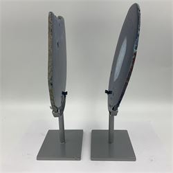 Pair of blue agate slices, polished with rough edges, raised upon silvered metal stands, H26cm