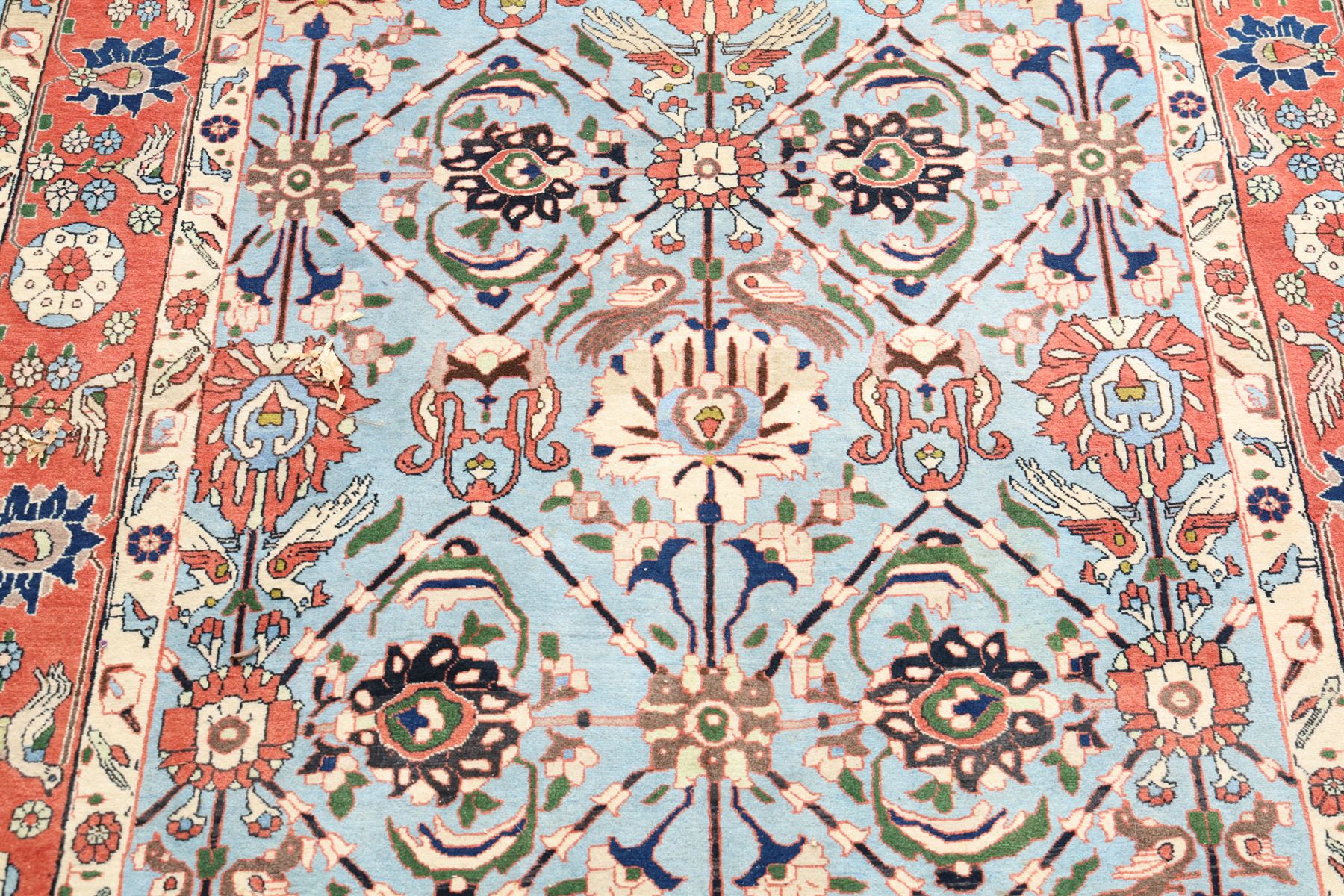 Persian Tabriz cyan ground rug of Benlian design, the field decorated with large palmette motifs, the crimson and ivory guard lines with repeating bird of paradise and interspersed stylised plant motifs