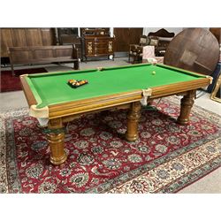 Late 20th century oak slate bed billiard table, on six turned column supports,  together with cues, ball set, baize brush, triangles and scoreboard 