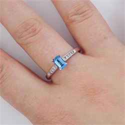 18ct white gold blue topaz and diamond ring, the single emerald cut topaz of approx 0.65 carat, each shoulder set with five, channel set princess cut diamonds