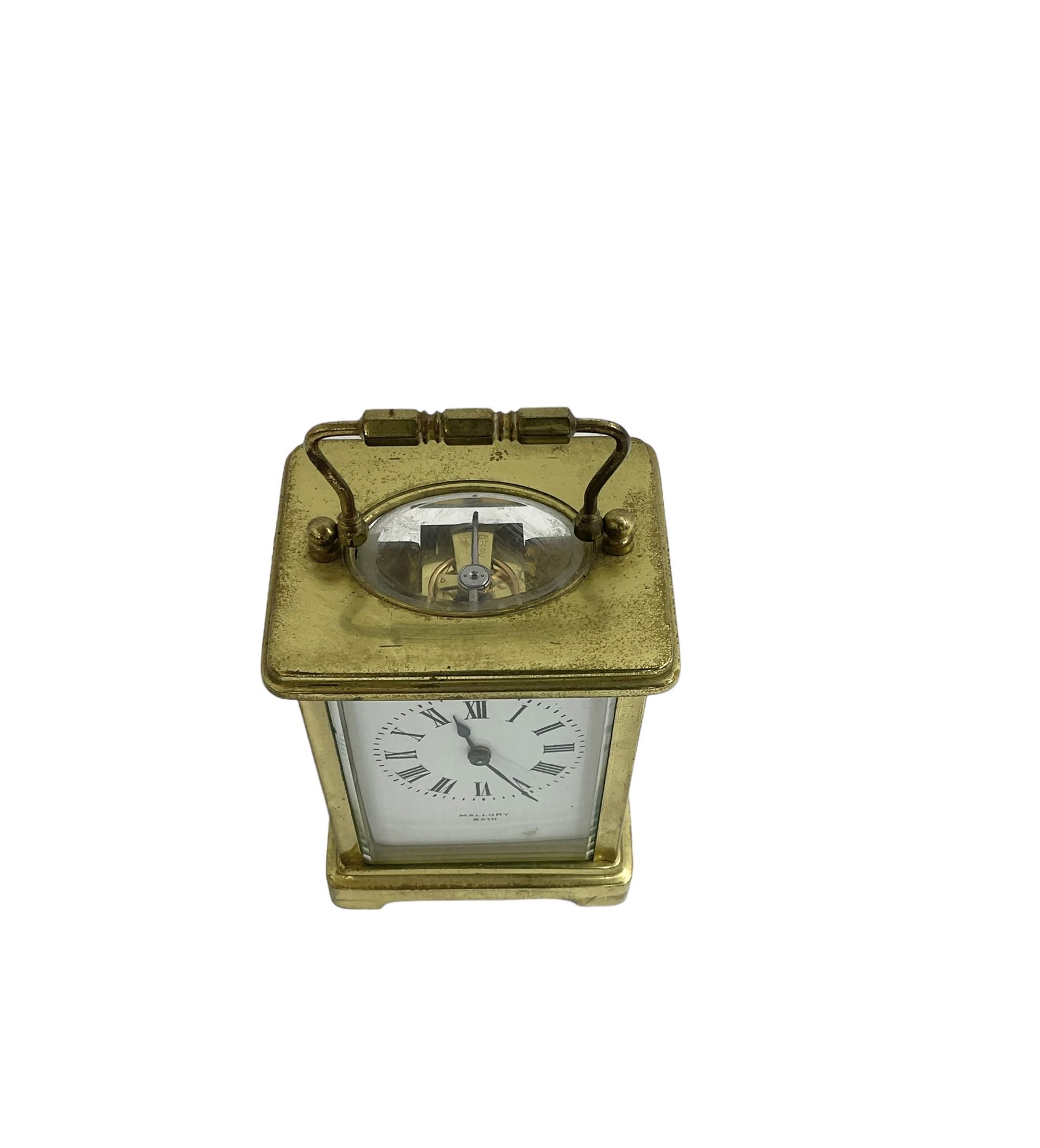 French - 20th century timepiece carriage clock, in a corniche case with carrying handle, enamel dial with Roman numerals, minute track, spade hands and retailers name “Mallory, Bath”, cylinder platform escapement, wound and set from the rear.