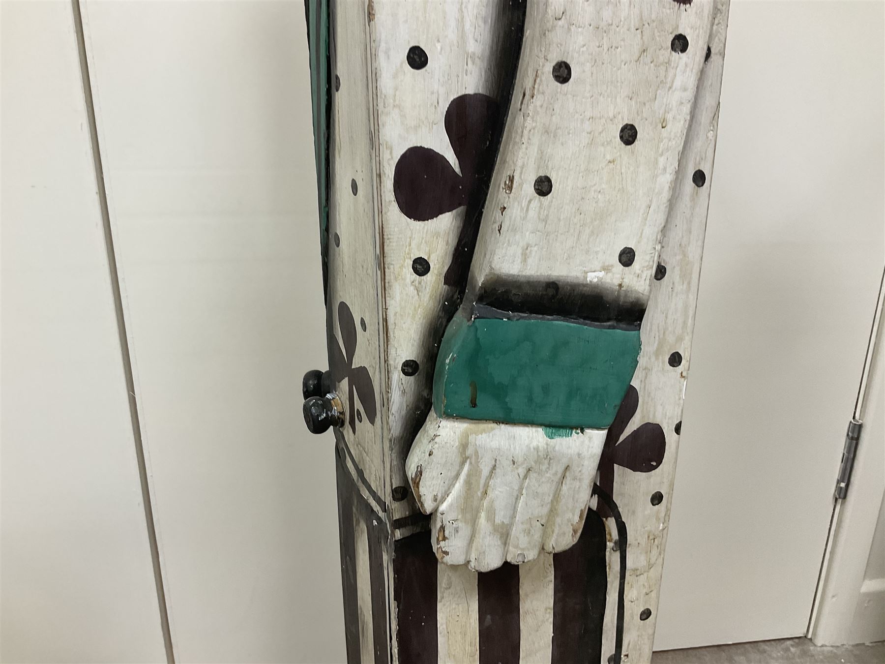 Folk art circus clown cabinet, the the two hinged doors with bow tie decoration opening to reveal fitted shelved interior, the body painted with polka dots and spades, H121cm