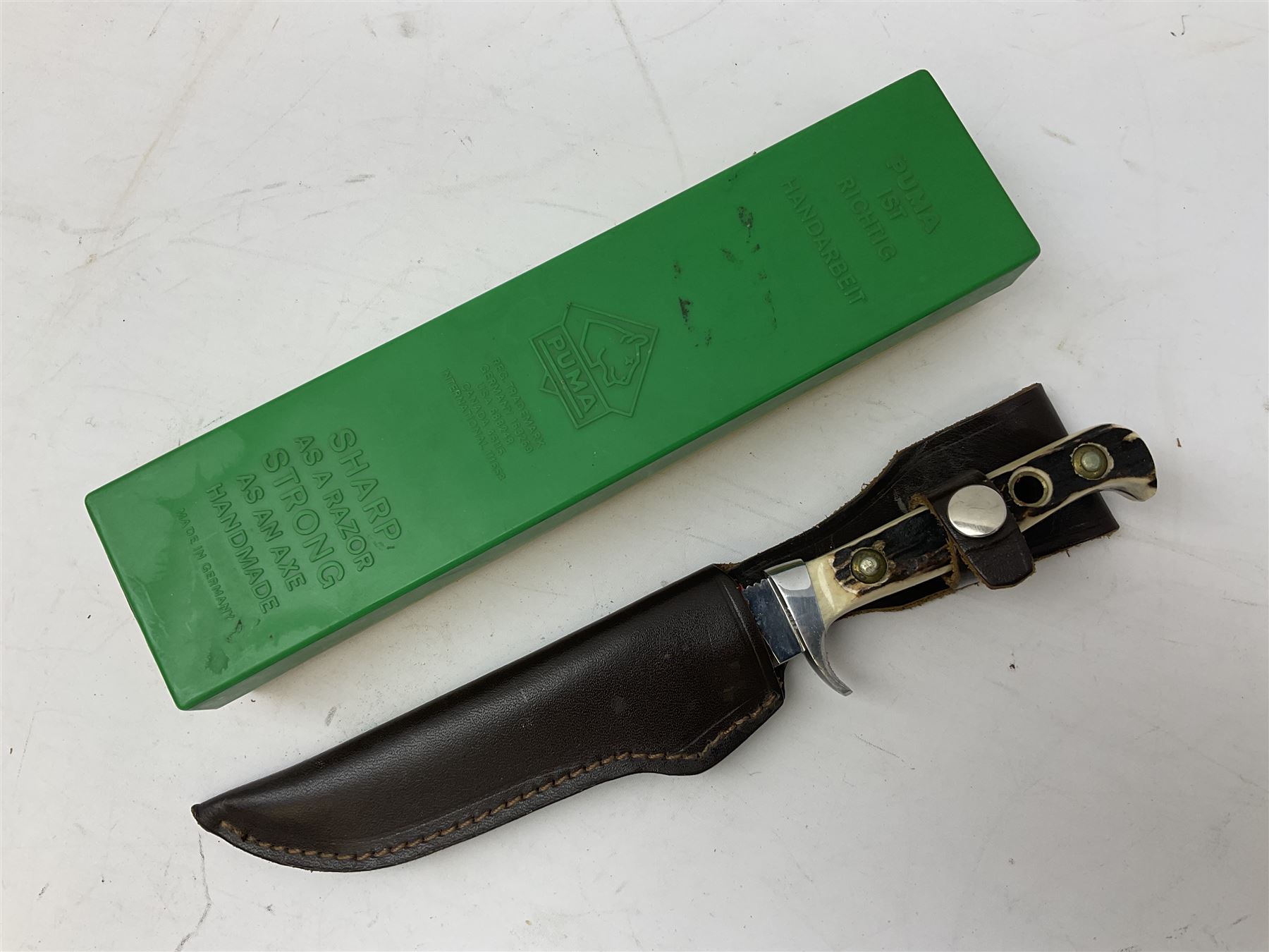 German Puma Skinner knife, the 13cm steel blade marked model 6393, serial No.55472 to guard, fixed blade, antler scales; in original hard plastic case; with brown leather sheath L29cm overall