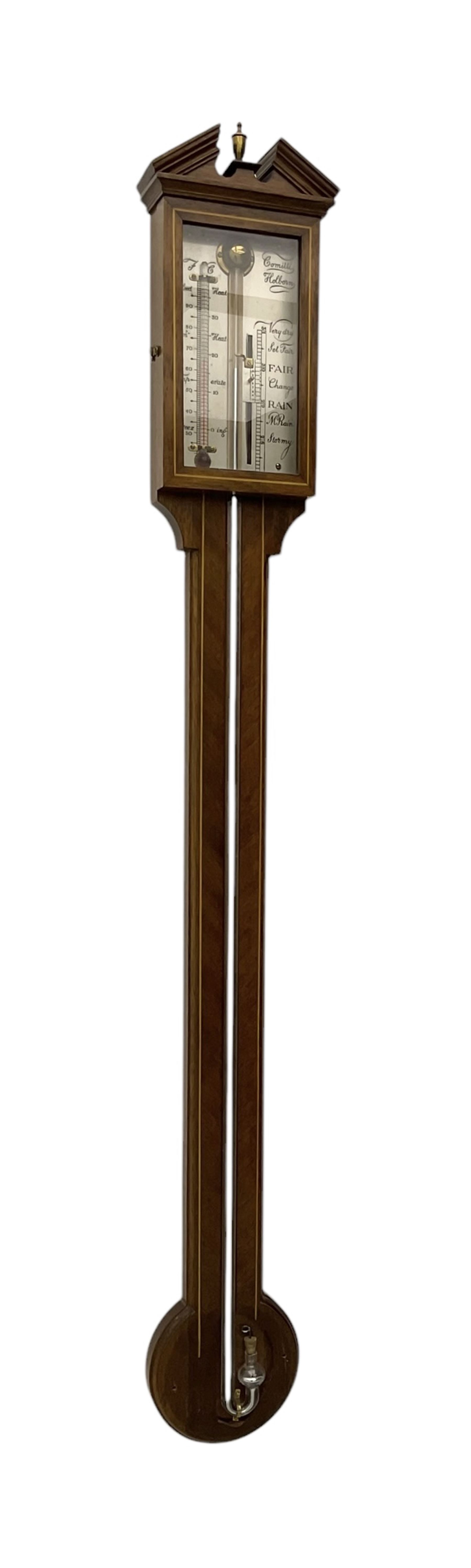 Comitti-20th century mercury stick barometer in an 18th century style mahogany case with satinwood stringing, with a broken pediment, brass finial and round base, silvered register with recording vernier, weather predictions and a centigrade/Fahrenheit spirit thermometer enclosed within a glazed door, visible tube with a bulb cistern and turned mahogany cover.
Mercury clean and present with no air locks.