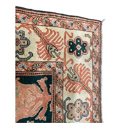 Persian emerald green ground rug, the field decorated with large stylised plant motifs, ivory ground border with repeating leaf motifs, the guards decorated with trailing branch and flowerhead motifs