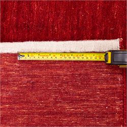 Two contemporary Moroccan Berber hand-woven rugs, deep madder red field of plain design, 199x153cm, other with deep madder red field with a simple lattice of ivory lines forming panels with some tonal variation, 190x146cm 