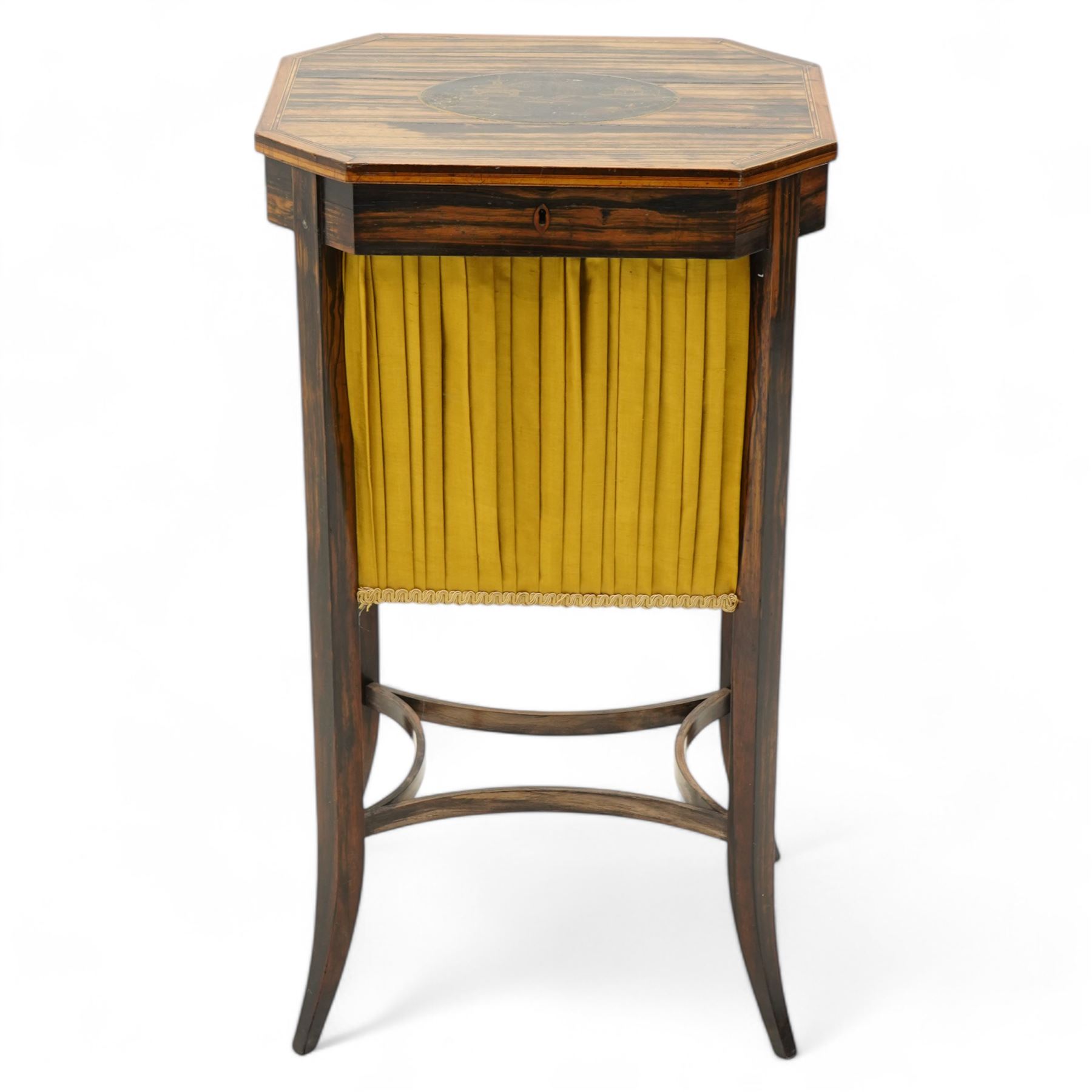 Edwardian coromandel wood work or sewing table, canted rectangular form, the hinged lid with central chinoiserie panel depicting traditional scene with boat, enclosing sunken storage well with pleated skirt, on square tapering supports with splayed feet united by curved stretchers 