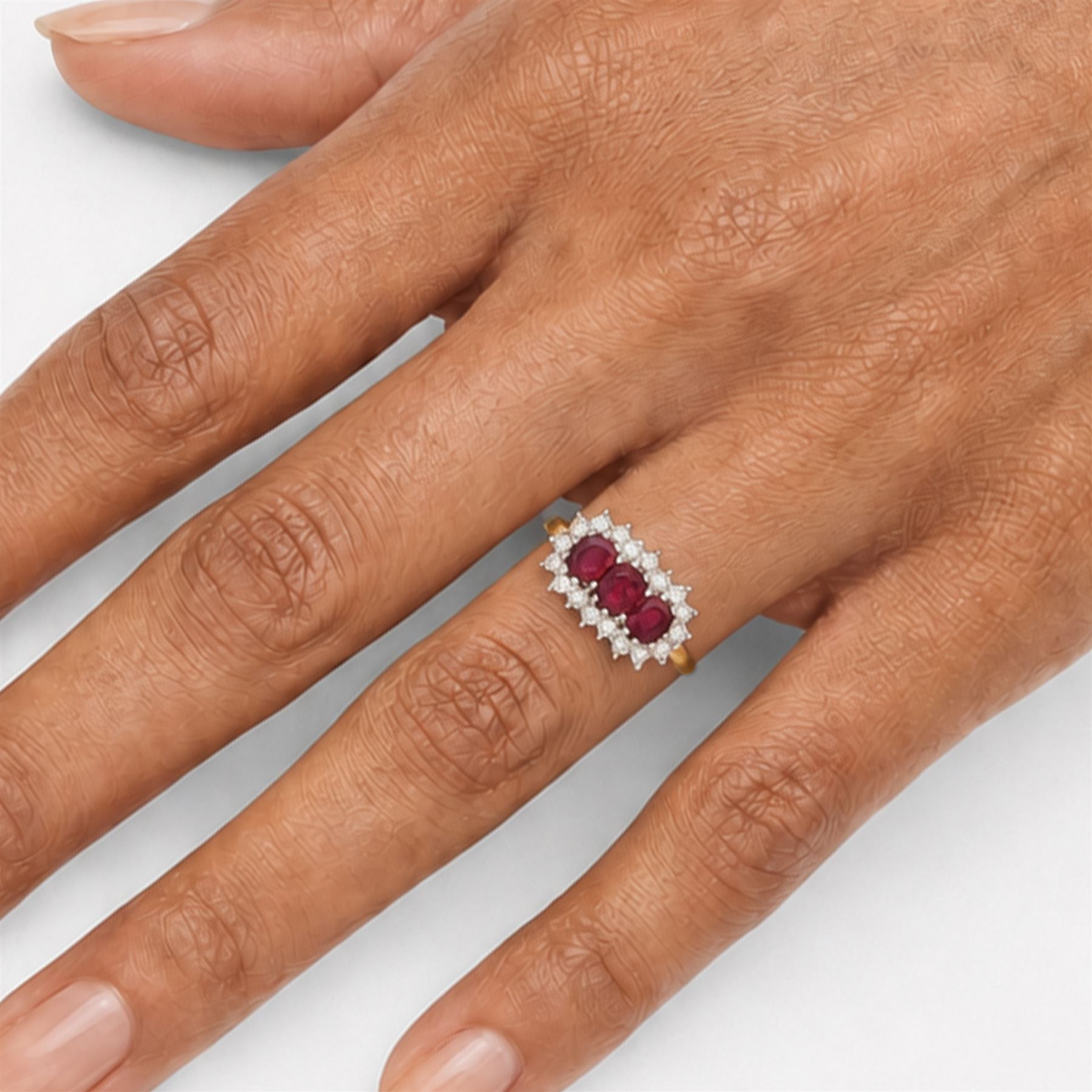 18ct gold ruby and diamond cluster ring, three oval cut rubies surrounded by eighteen single cut diamonds, London 1979, total ruby weight approx 0.55 carat, total diamond weight approx 0.20 carat