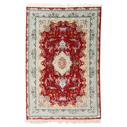 Fine Persian silk inlaid crimson ground Tabriz rug, the shaped field decorated with a cent...