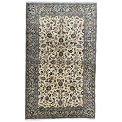 Persian Kashan ivory ground rug, decorated with interlaced leafy branches and stylised plant motifs, guarded border with scrolling design