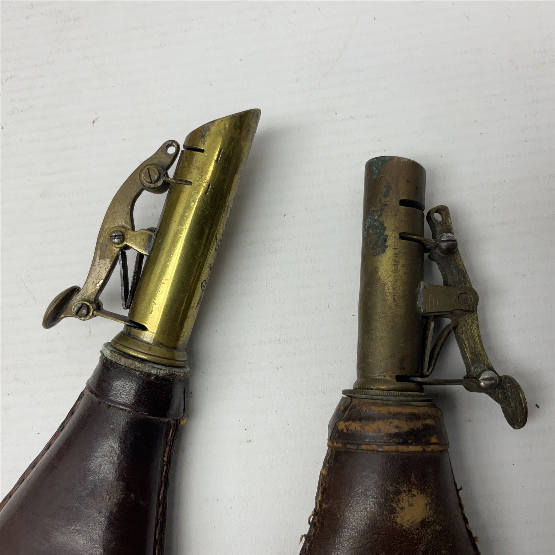 Two leather shot flasks with embossed decoration and brass nozzles; scissor action bullet mould with two ladles; pair of 19th century J.B. Warrilow hammer actions; small quantity of Staybrite buttons; and 1968 dated metal ammunition tin for 200 x 7.62 blank cartridges