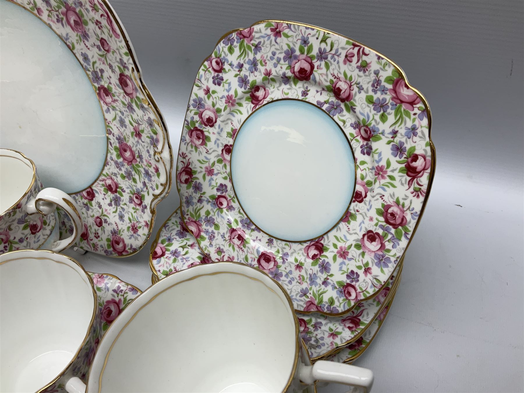 Windsor tea service for six decorated with blooming pink roses and purple flowers amongst foliage