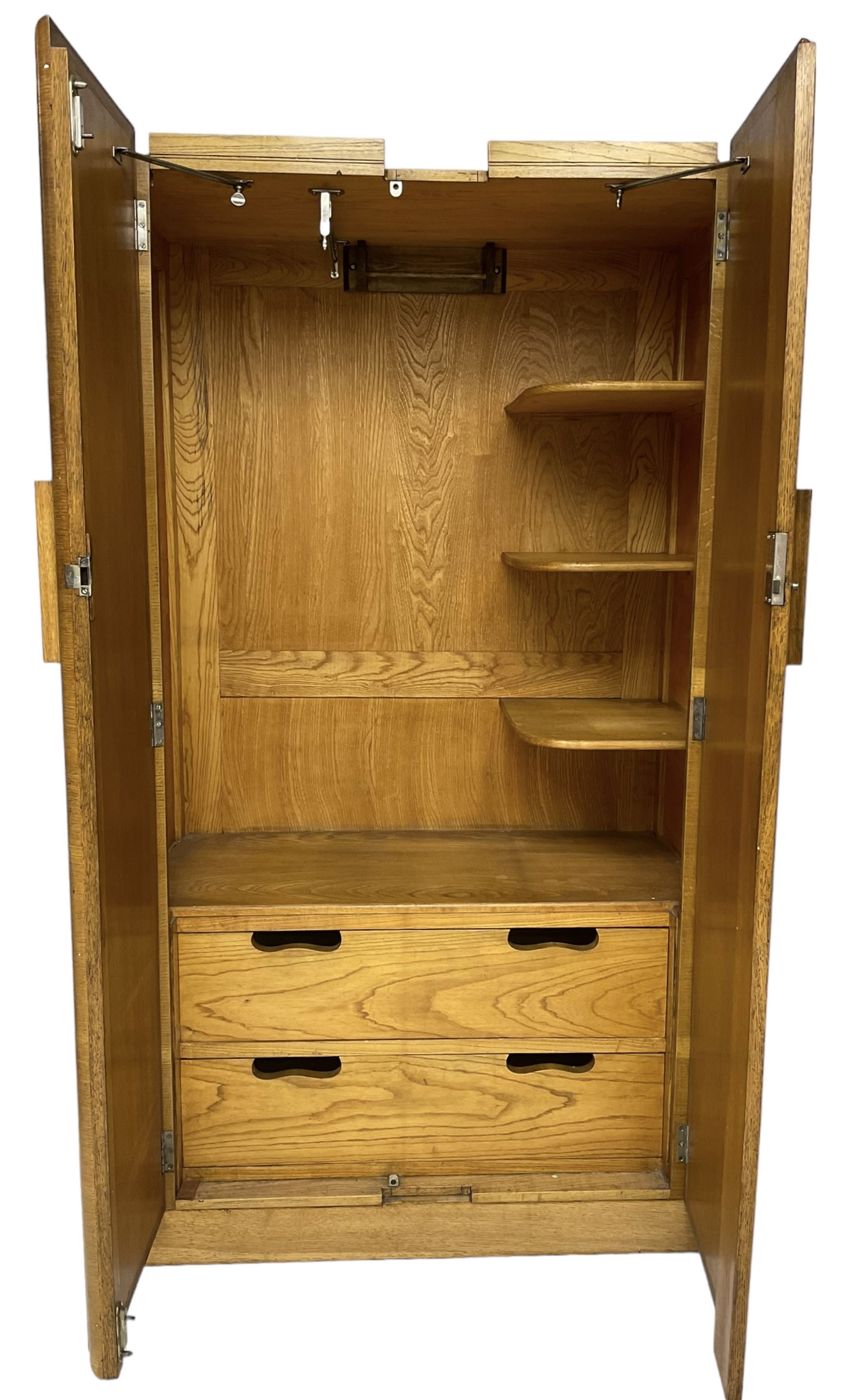 Early 20th century Art Deco period oak Gentleman's wardrobe, the interior fitted with shelves, hanging rails and two long drawers