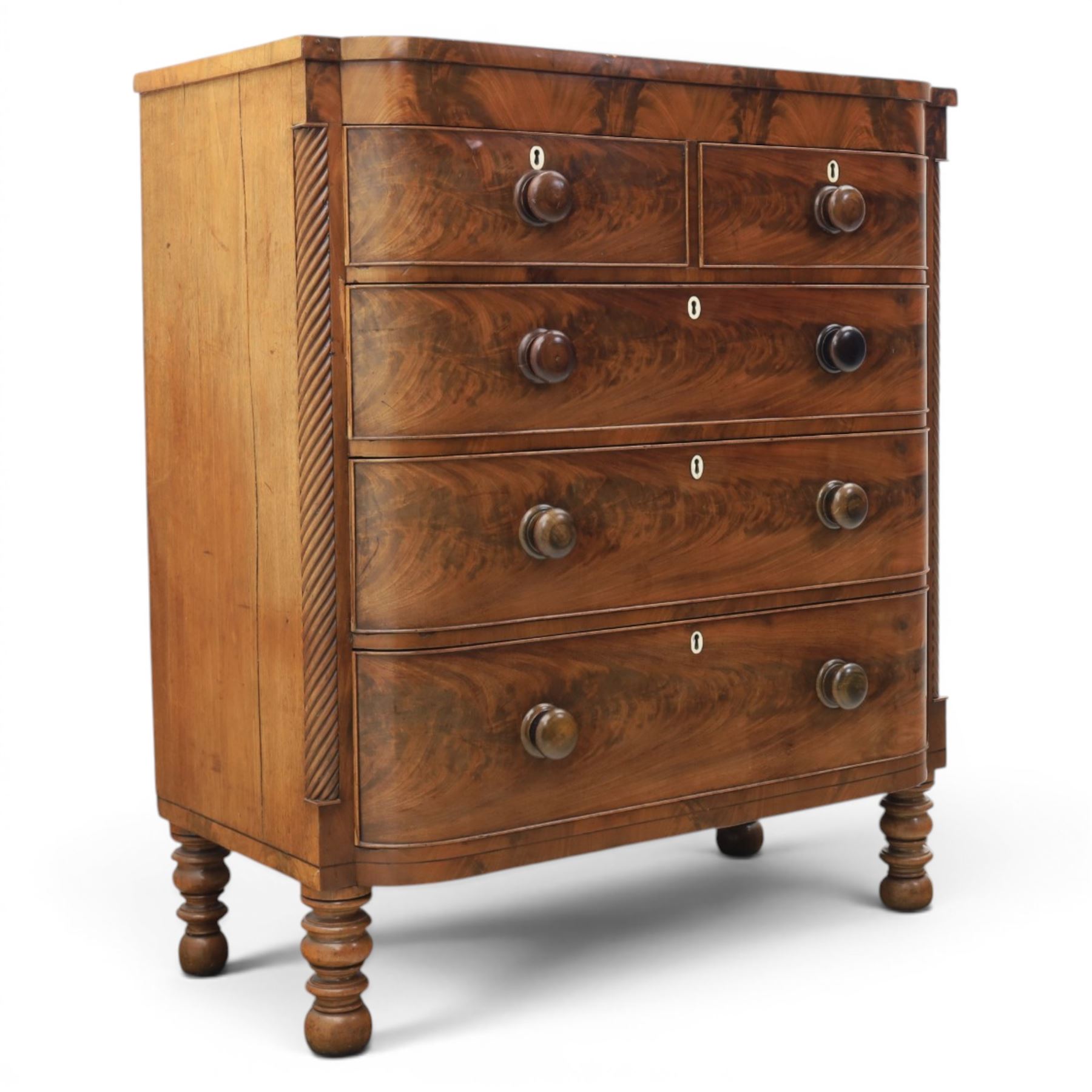 Victorian mahogany bow fronted chest, fitted with two short and three long drawers, flame mahogany front, bone escutcheons and turned wooden handles, quarter barley twist columns, raised on turned supports