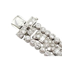 Art Deco platinum diamond and ruby bracelet, circa 1920-1930, the central panel set with a single emerald cut diamond of approx 0.55 carat, flanked by two baguette cut diamonds and old cut diamond surround, the articulated geometric design bracelet with vari-cut rubies, round and baguette cut diamonds, total diamond weight approx 7.00 carat, in Mappin & Webb silk and velvet lined box