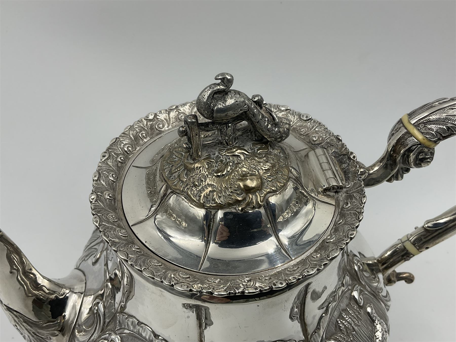 Victorian silver three piece tea service, comprising teapot, twin handled open sucrier, and milk jug, each of bellied form with acanthus capped scroll handles, the sides embossed with alternating scroll edged vacant panels and panels containing a pair of birds, upon four palmette feet, the teapot with ivory insulators to handle, and bird finial to the hinged domed cover, hallmarked William Hunter & Son, London 1861, teapot H19cm, including handles sucrier H13.5cm, including handle milk jug H12cm

This item has been registered for sale under Section 10 of the APHA Ivory Act