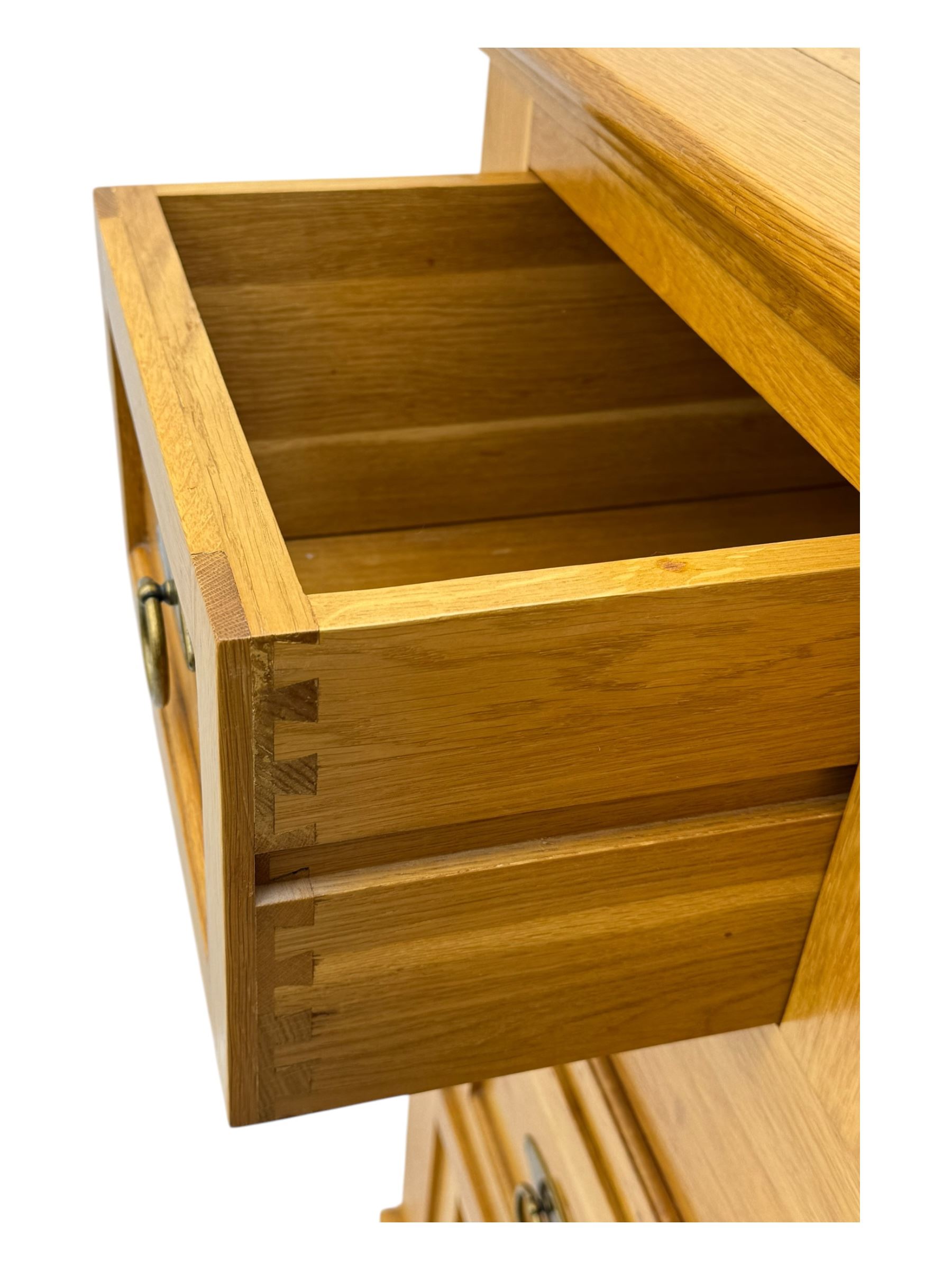 Frank Hudson - contemporary light oak chest, rectangular moulded top over two short and three long drawers, brass oval backplates with circular drop handles, on a moulded plinth base with bracket feet