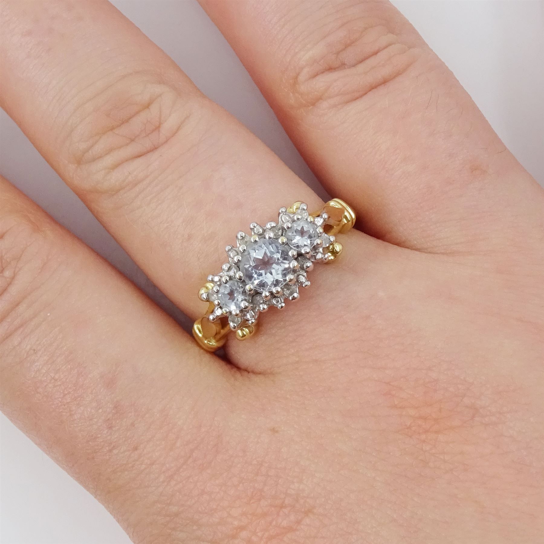 9ct gold aquamarine and diamond cluster ring, three round cut aquamarines, with diamond chip surround and scroll design shoulders, hallmarked