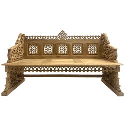 Carved teak garden bench, the cresting rail carved and pierced with foliate design, shaped arms and end supports decorated with scrolling foliage and flower heads
