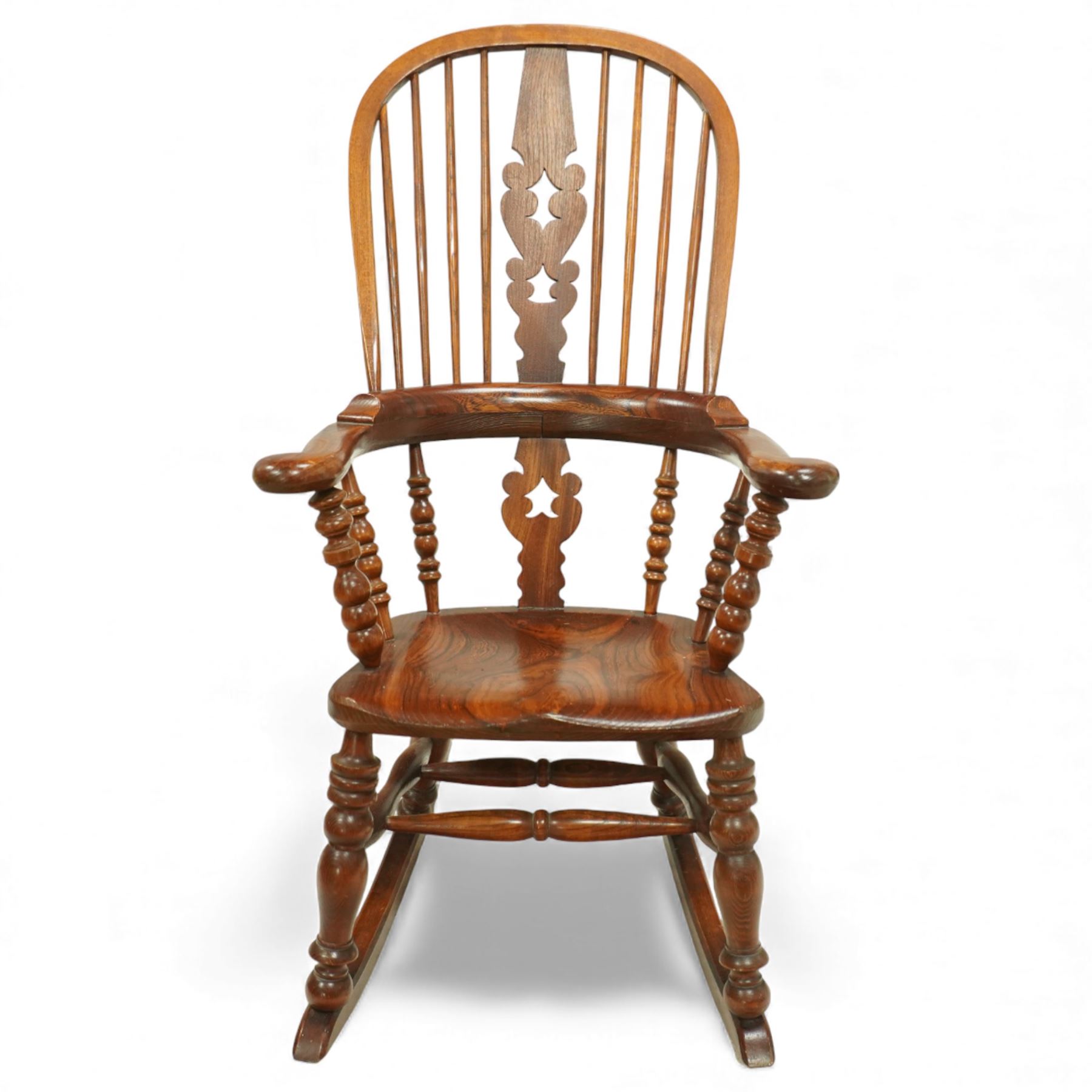 Broadarm Windsor rocking chair, arched crest rail enclosing turned spindle back with pierced splat, wide shaped arms with turned supports, solid elm seat, raised on turned legs united by double stretchers, on swept rockers