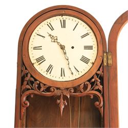 Late 19th century Vienna walnut regulator wall clock, arched glazed case with moulded cornice and figured walnut veneers, circular enamel dial with Roman numerals and pierced hands, carved foliate fretwork beneath the dial, single pendulum movement with brass weights and glazed lower section