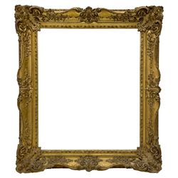 Victorian giltwood and gesso wall mirror, the deep swept frame decorated with scrolling foliate, acanthus leaf corner cartouches and applied trailing flower heads, the outer edge decorated with egg and dart foliage mouldings, plain mirror plate enclosed by scrolled foliate inner slip
