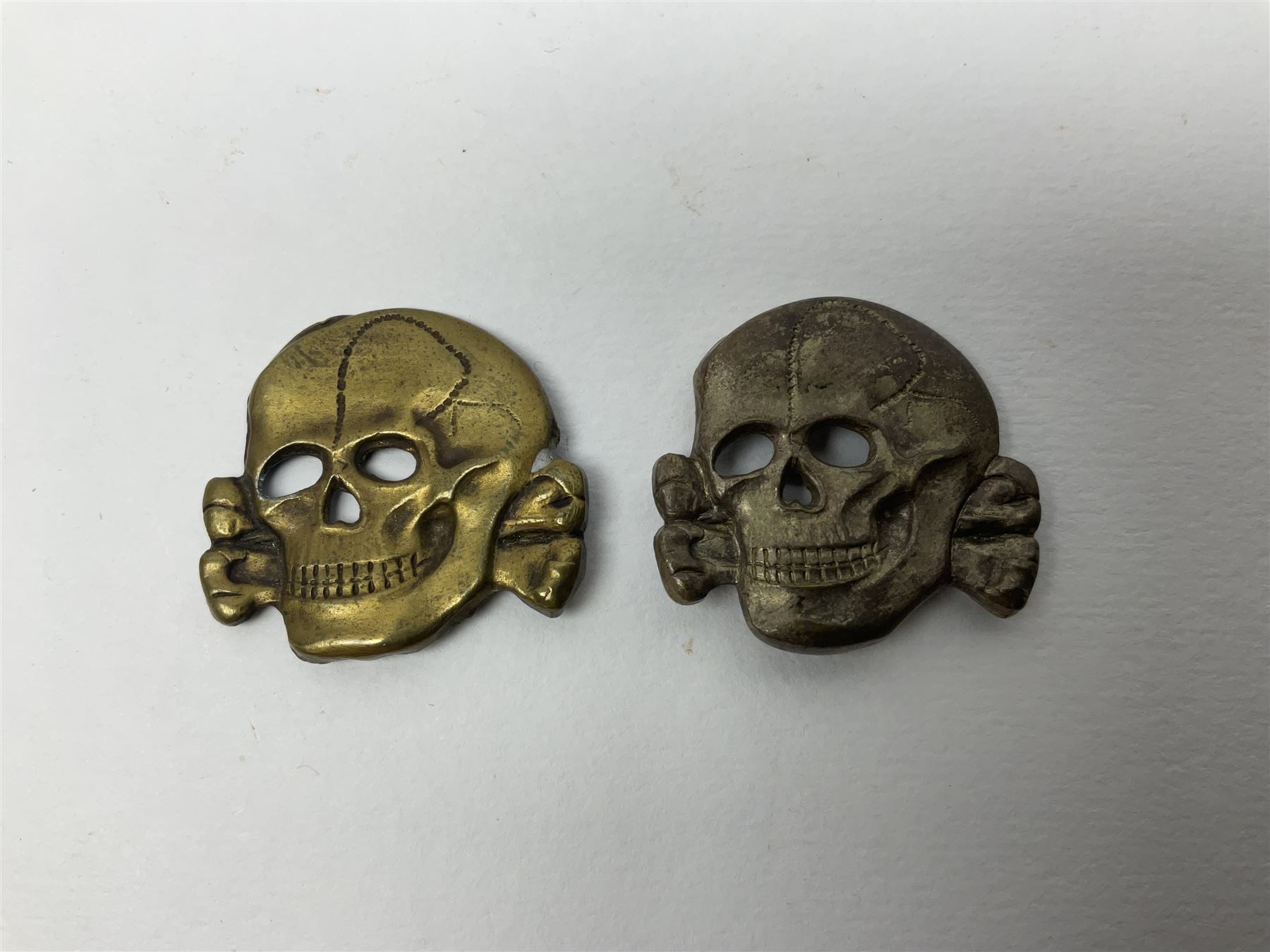 Five German 'SS' visor cap metal badges comprising one eagle and four skull and cross-bones (5)