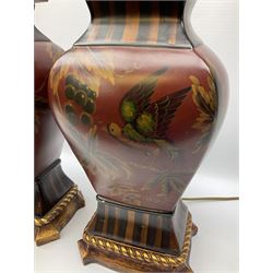 Pair Oriental table lamps decorated with birds in a tree with fruit, on a red ground with a gilded base together with cream lampshades H57cm, without lampshade. 