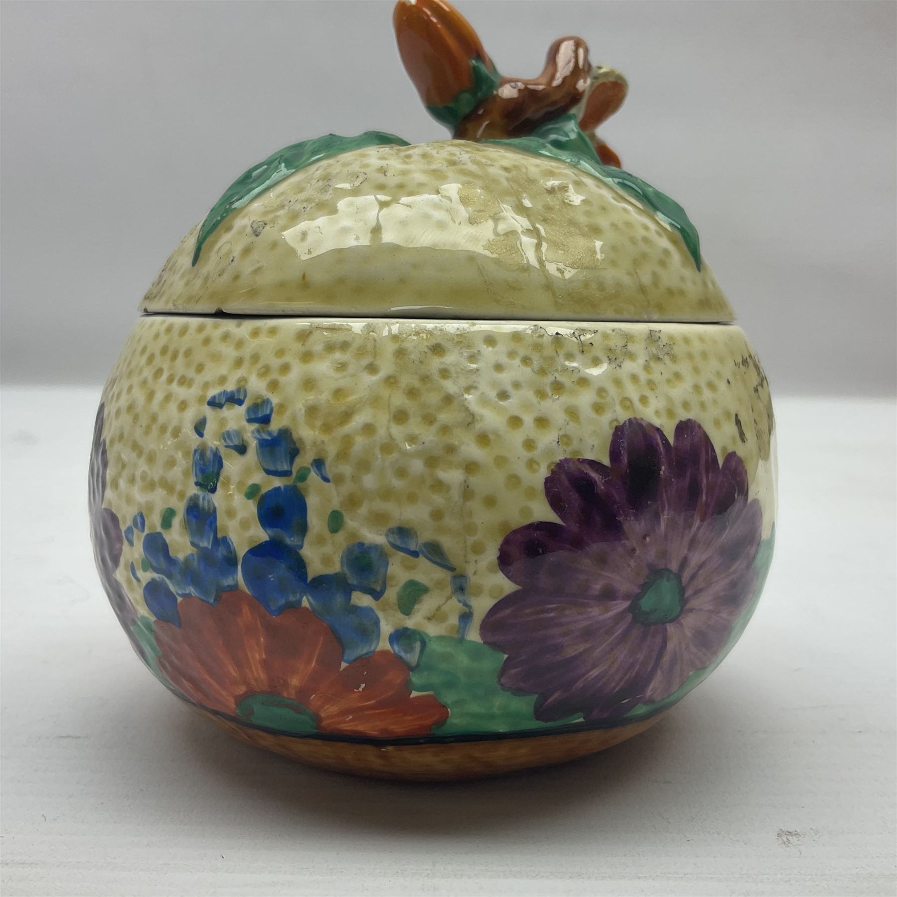 Clarice Cliff for Newport Pottery ceramics, comprising preserve jar and Bon Jour shape teacup, both in Crocus pattern, together with a Clarice Cliff for Wilkinson Ltd, preserve jar with cover, in Gayday pattern, preserve jar H10cm