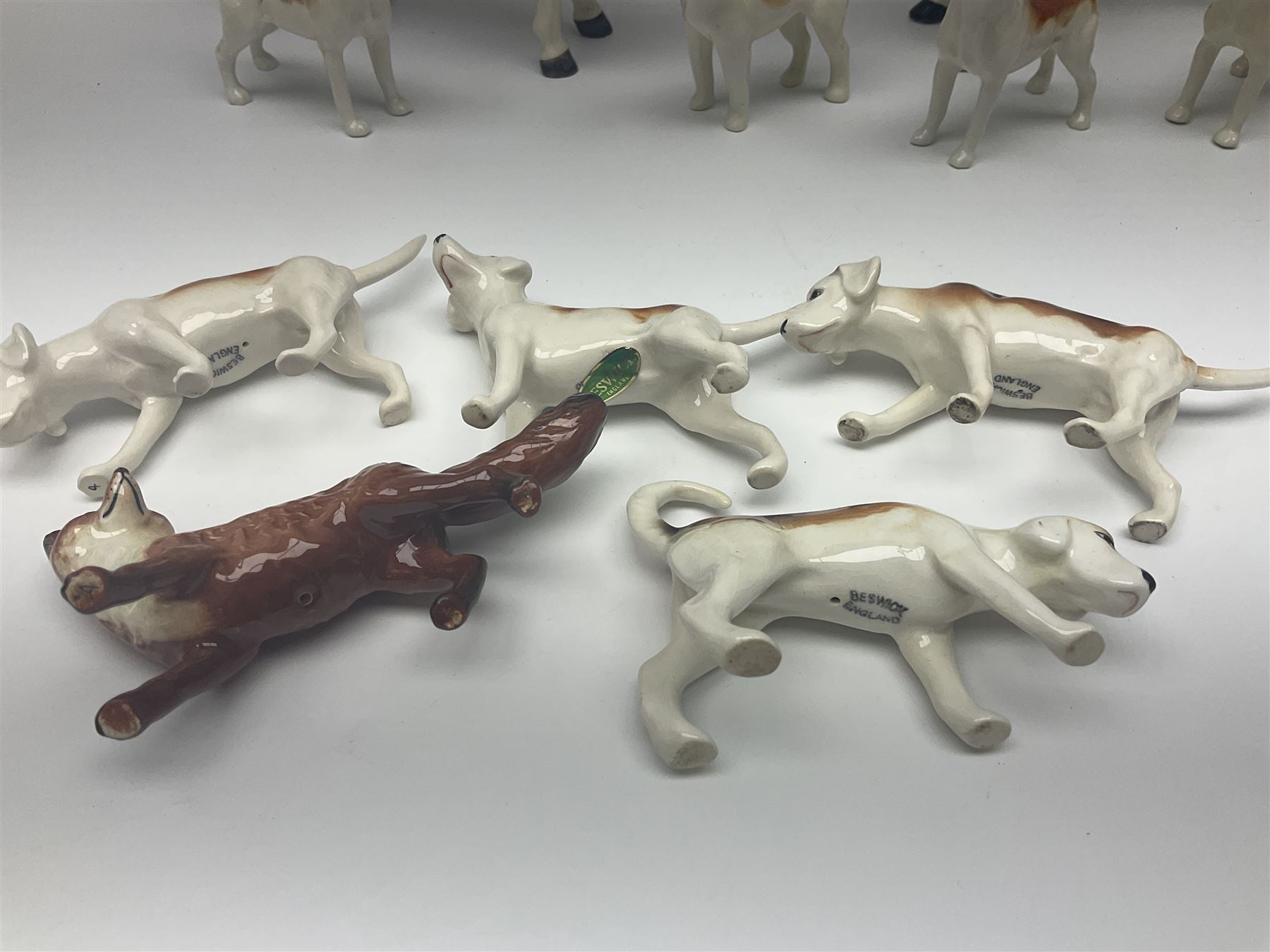 Beswick hunting group, comprising huntswoman on grey horse no 1730, huntsman on brown horse no 1501, fox figure no 1440 and eight fox hounds, all with printed marks beneath (11)