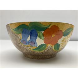1930s Clarice Cliff Bizarre for Newport Pottery bowl, decorated in the Canterbury Bells pattern, the exterior painted with stylised flowers in blue, yellow and orange amongst foliage upon a brown and yellow Cafe au Lait stippled ground, with black printed mark beneath, D18cm