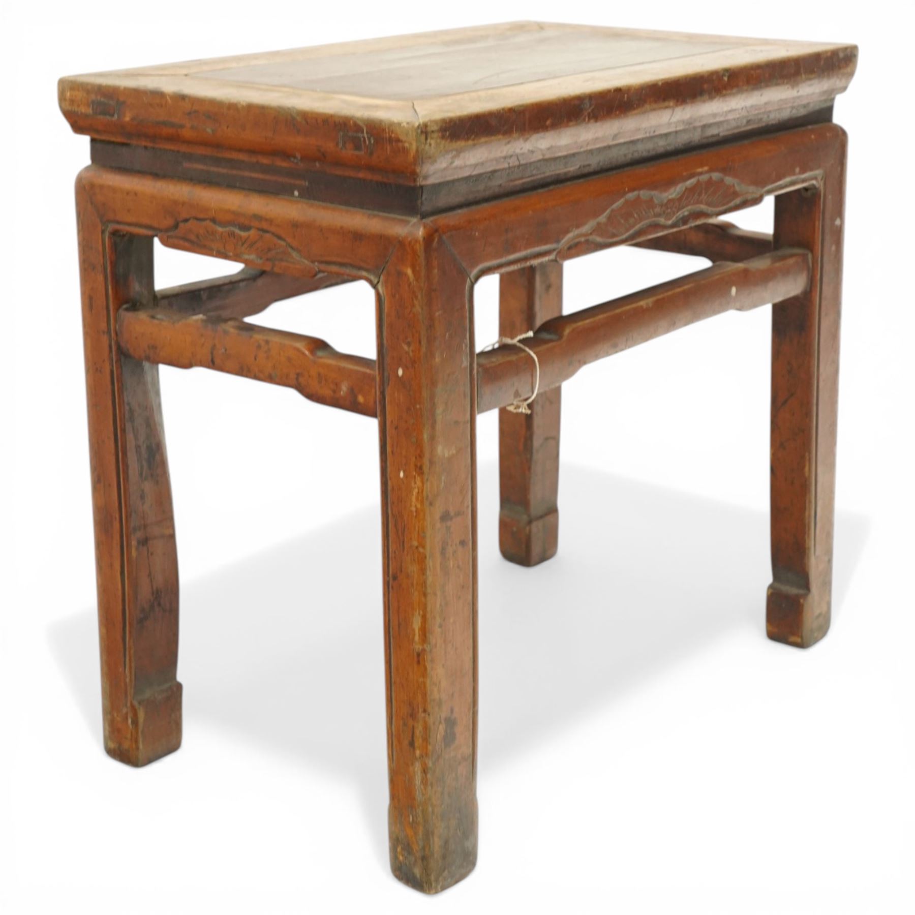 Near pair of 19th century Chinese lacquered elm occasional tables, rectangular top over a bat-motif carved frieze, shaped stretcher rail over tapering supports
