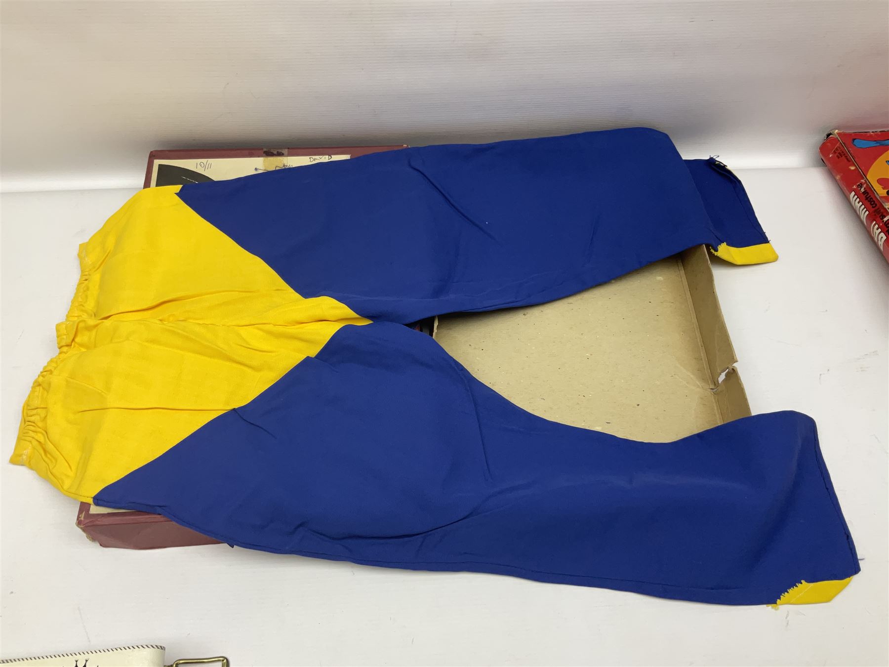Two Boxed Batman Playsuit Costumes - 1960s 20th Century Original Play Suit, black eye mask, plastic vinyl cape/gauntlets, leather style belt, blue/yellow shirt, with Bat motif and blue/yellow pants; in original illustrated lidded box; and 1976 Decker Batman Playsuit costume, vinyl cape/ mask/gloves/boot tops/yellow belt, grey cloth top and pants; in original illustrated box (2)