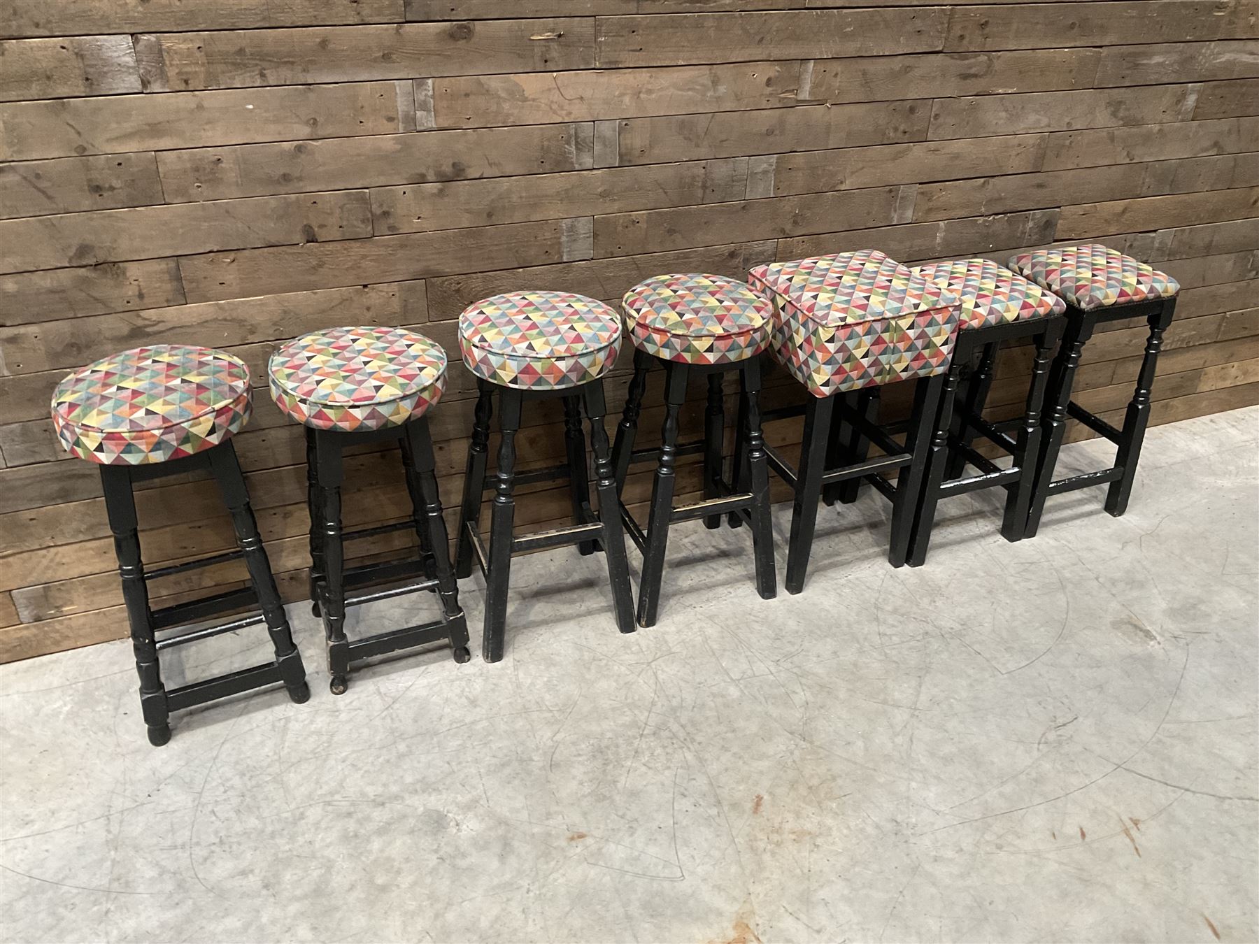 Seven tall bar stools with upholstered seat