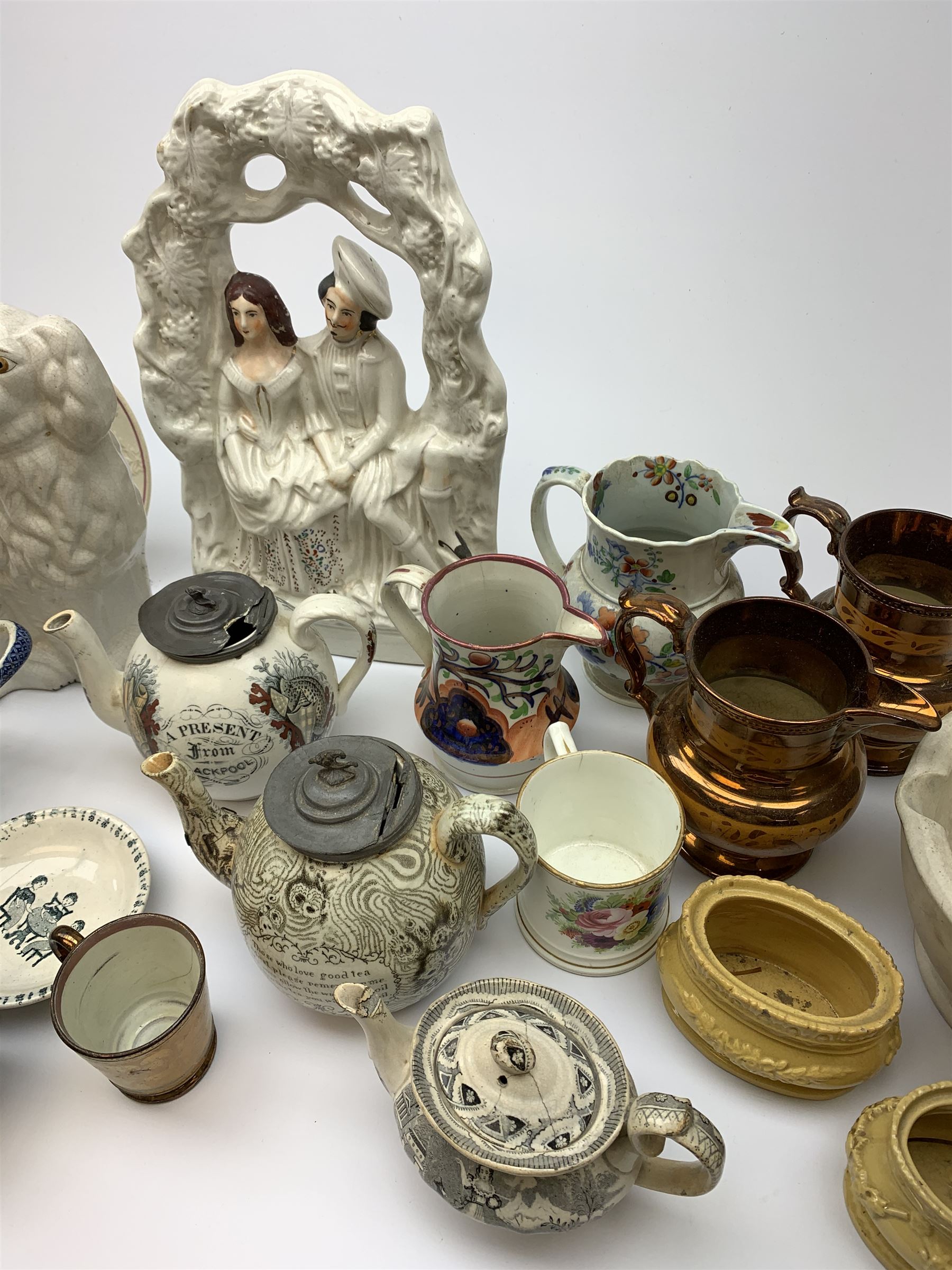 A group of 19th century ceramics, comprising agateware teapot with pewter cover, the body detailed with verse, a further example detailed A Present from Blackpool, large Wedgwood best composition mortar, two copper lustre jugs and a small cup, floral print decorated jug possibly Don Pottery, Gaudy Welsh jug, floral painted mug, Staffordshire nursery plate, teapot, and teacup and saucer, reticulated chestnut basket, Staffordshire bough group, plus a later Staffordshire style dog. (9). 